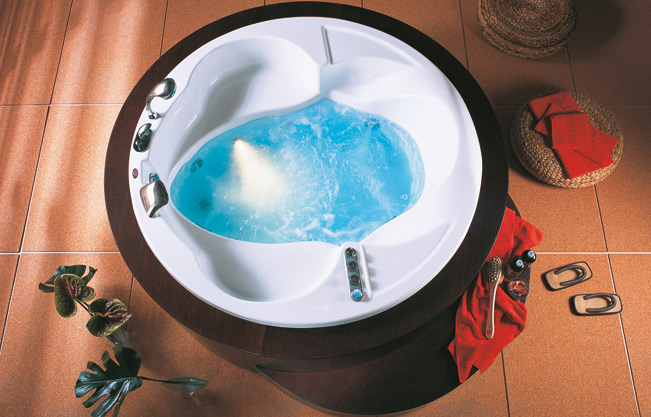 Two-seater circular bath with anatomical curves. It has soaps an